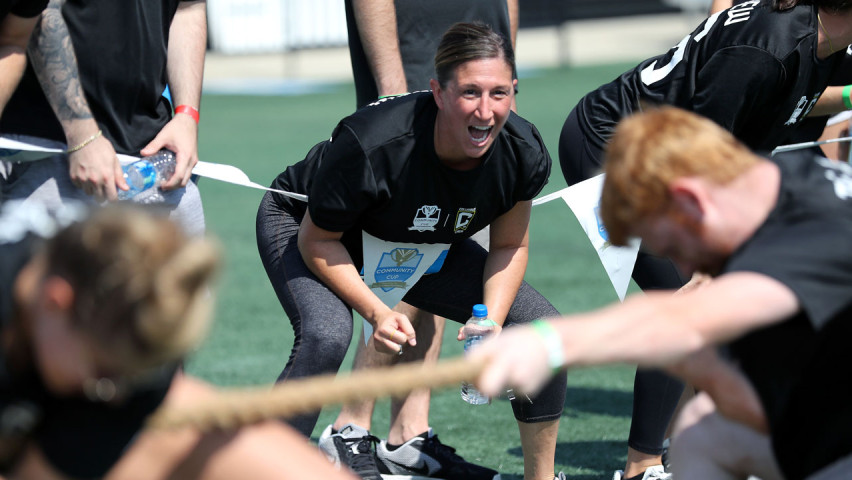 Woman cheering teammates on for tug of war