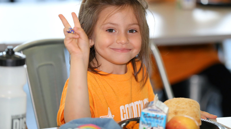 kid throwing up peace sign