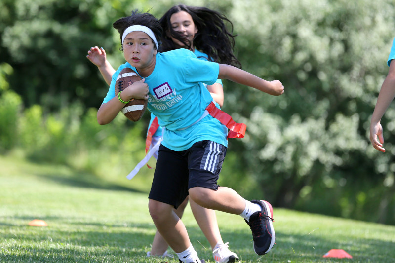 young camper kicking a karate pad